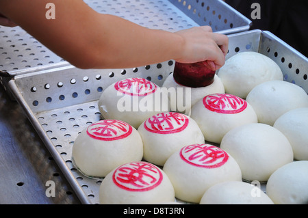 Gedämpfte Brötchen wird gestempelt in Vorbereitung auf das jährliche Cheung Chau Bun Festival, Hong Kong Stockfoto