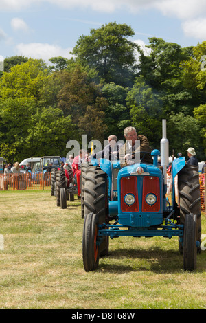 Eine Parade von Oldtimer-Traktoren, angeführt von einem Fordson Super Major, in den Haupt-Show-Ring auf der Heskin Hall Steam Fair 2013.