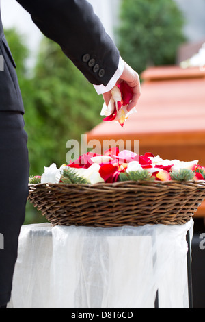 Trauer um Frau auf der Trauerfeier mit Blumen am Sarg oder Sarg stehen Stockfoto