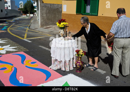 Fronleichnam in Alcala, stellt alte Dame in schwarz ein Kruzifix an einen temporären Altar vor ihrem Haus festhalten an ihren Sohn zum Stockfoto