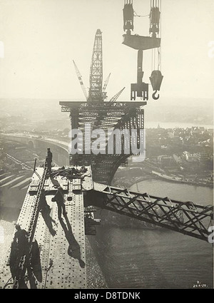 Dieses Schwarzweiß-Foto der Sydney Harbour Bridge zeigt Panel Point 7 des Western Truss. Es bietet einen historischen Überblick über den Bauprozess und hebt den Einsatz von Kränen und Arbeitern hervor, die an der Montage der Brücke beteiligt sind. Das Bild ist Teil des Archivs der State Records of New South Wales. Stockfoto