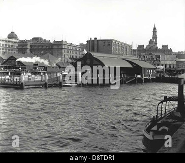 Dieses historische Schwarzweiß-Foto der Werften am Circular Quay in Sydney, New South Wales, zeigt eines der wichtigsten Verkehrs- und Handelsknotenpunkte der Stadt. Der Circular Quay, der sich am Rand des Hafens von Sydney befindet, ist ein zentraler Punkt für Fähren, Züge und Busse und bietet einen belebten Blick auf das Meer. Stockfoto