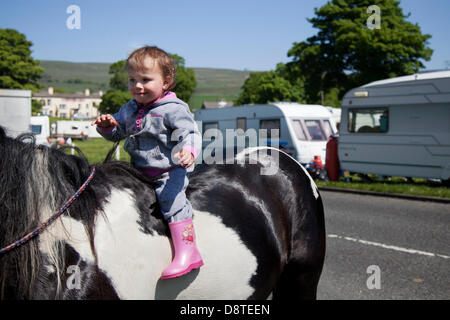 Bainbridge, Richmondshire, North Yorkshire, UK 4. Juni 2013.  Lily Corrie, 2 Jahre auf dem Pferderücken ein Familienmitglied die Reisen Gemeinschaft auf dem Weg in die Appleby Horse Fair in Cumbria.  Die Messe ist ein jährliches Treffen der Zigeuner und Reisende die erfolgt in der ersten Woche im Juni, und seit der Regierungszeit von James II., der eine königliche Charta 1685 ermöglicht ein Pferd gewährt fair "in der Nähe des Flusses Eden". Bildnachweis: Mar Photographics/Alamy Live-Nachrichten Stockfoto