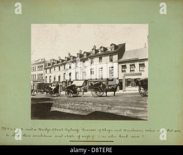 Ein Schwarzweiß-Archivfoto von Bridge Street, Sydney, das die historische Landschaft mit Pferdekutschen und Terrassenhäusern zeigt. Das Bild bietet einen Einblick in das Sydney des frühen 20. Jahrhunderts und fängt das tägliche Leben und die Architektur ein. Stockfoto
