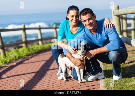 schöne junge Paar und Hund am Strand Stockfoto