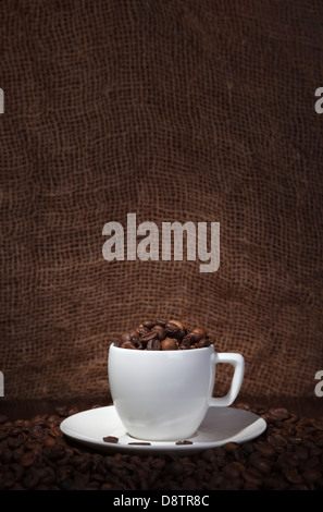 Tasse mit Kaffeebohnen auf dunklem Hintergrund Stockfoto