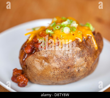 Gebackene Kartoffel mit Chili und Käse auf einen Teller geladen Stockfoto