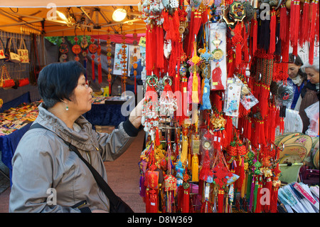 Frau betrachten chinesische Glücksbringer auf dem Nachtmarkt in Chinatown, British Columbia, Kanada Stockfoto