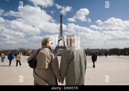 Ehepaar im Ruhestand (70er Jahre) Hand in Hand und reden, Eiffelturm im Hintergrund. Paris, Frankreich Stockfoto