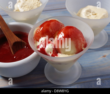 Platzierung in einzelnen Dessert Schalen, die Pfirsiche, Eis und Himbeer-Püree Stockfoto