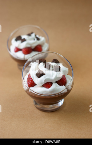 Schokoladen Creme-Desserts mit Baiser und Erdbeeren garniert Stockfoto