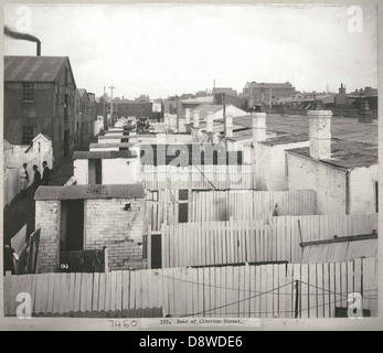 Ein historisches Schwarzweißfoto der Alderson Street in Sydney, New South Wales. Das Bild zeigt eine Vintage-Straßenszene mit einem Fokus auf ein heruntergekommenes Haus, ein Outthouse und die industrielle Atmosphäre der Gegend. Es beleuchtet Armut und die alltäglichen Kämpfe der Vergangenheit in der Region, die aus State Records NSW stammen. Stockfoto
