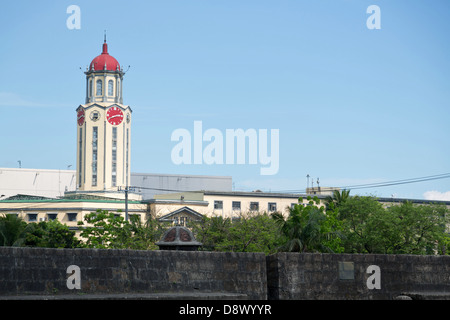 Blick auf einen Uhrturm über der Stadtmauer von Intramouros in Manila, Philippinen Stockfoto