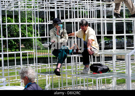 Ein paar entspannende in der Serpentine Gallery Pavillon, entworfen von Sou Fujimoto. London, Vereinigtes Königreich. Stockfoto