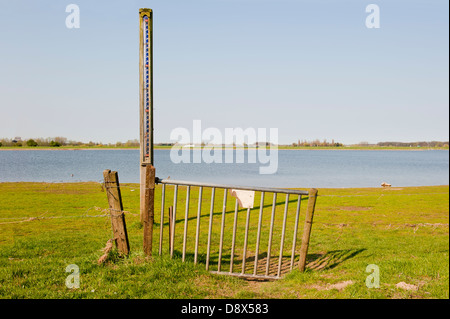 Eisernes Tor mit der Skala des Wasserspiegels in den Auen des Flusses IJssel bei Ebbe, Niederlande Stockfoto