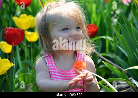 Kleinkind Mädchen spielen in der Tulpen. Stockfoto