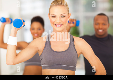 Gruppe von fröhlichen Menschen Übung im Fitnessstudio mit Hanteln Stockfoto