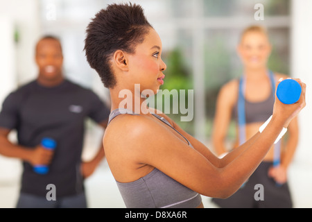 Seitenansicht der afroamerikanische Frau, die Hantel mit beiden Händen anheben Stockfoto