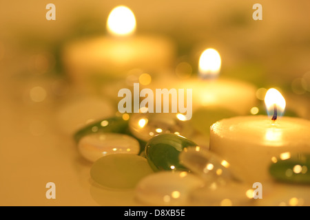 Brennenden Kerzen umgeben von Glasperlen Stockfoto