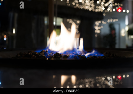 Blaue Flammen brennen über Kohlen vor der weißen Leuchten Stockfoto