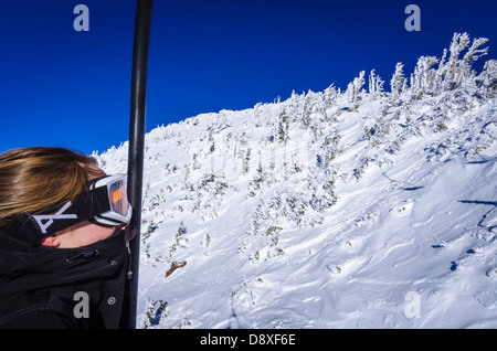 Junge Frau mit Sessellift am Mammoth Mountain Ski Area, MammothLakes, Kalifornien USA Stockfoto