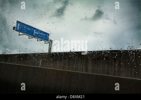 Durch eine nasse Fenster gesehen. Autobahn-Ausfahrt Stockfoto