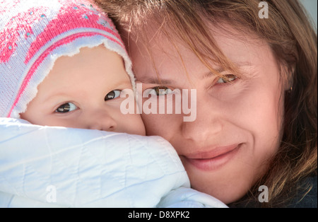 Junge europäische Frau hält ihr sleepy Baby in Decke. Outdoor Closeup portrait Stockfoto