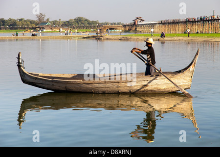 Bootsmann Rauchen eine Cheroot Taungthaman See, Myanmar, mit Teak U Bein Brücke im Hintergrund Stockfoto