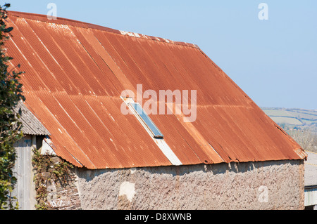 Devon Scheune mit Rost rot Wellblechdach vor Hintergrund der blauen Frühlingshimmel. Stockfoto