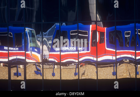 England, London, Docklands Light Railway train Wagen spiegelt sich in Glas Bürogebäude. Stockfoto