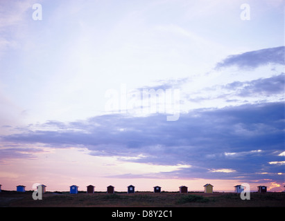 Badehäuschen in Folge gegen eine Dämmerung Himmel. Stockfoto