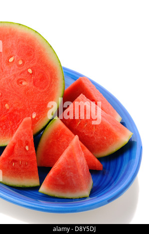 Nahaufnahme einer kernlose Wassermelone auf einer blauen Platte. Eine halbe Melone Keile von Früchten umgeben. Stockfoto