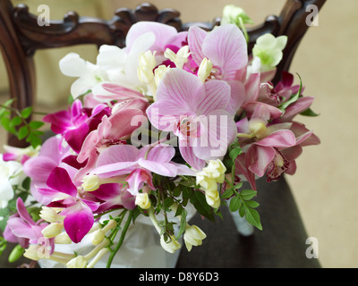 Ein Spray von Hochzeitsblumen mit Mischung aus rosa und weißen Orchideen, platziert auf einem Holztisch. Stockfoto