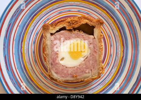 Scheibe von Pork Pie mit Ei in auf gestreifte Platte Stockfoto