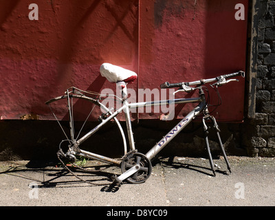Reste der roten Wand gelehnt Fahrrad Stockfoto