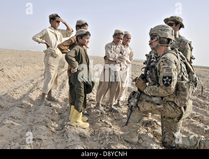 US Army 1st Lt. James Whitler spricht mit Kindern während seiner Einheit eine abgesessene Patrouille 2. Juni 2013 in der Nähe von Forward Operating Base Spin Boldak, Provinz Kandahar, Afghanistan führt. Stockfoto