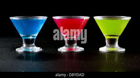 hellen Mini Martinis serviert auf einem nassen dunklen bar oben für einen dramatischen Effekt Stockfoto