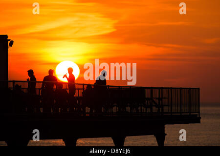 Aberystwyth, Wales, UK. 6. Juni 2013.   Am Ende eines anderen Tages warme Sonnentage mit Temperaturen in den niedrigen 20er Jahren Grad Celsius, eine Gruppe von Menschen sind bei Sonnenuntergang am Ende der viktorianischen Seestadt Pier in Aberystwyth Wales UK Foto von Keith Morris/Alamy trinken Live-Nachrichten Stockfoto