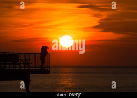 Aberystwyth, Wales, UK. 6. Juni 2013.   Am Ende eines anderen Tages warme Sonnentage mit Temperaturen in den niedrigen 20er Jahren Grad Celsius, ein paar sind Sonnenuntergang am Ende der viktorianischen Seestadt Pier in Aberystwyth Wales UK Foto von Keith Morris/Alamy Live-Nachrichten Stockfoto