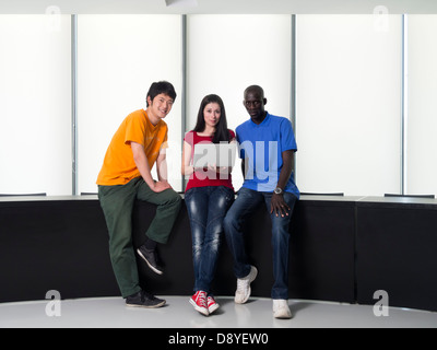 Schwarzer Mann, asiatischen Mann und kaukasischen Frau versammelten sich um einen Laptop-computer Stockfoto