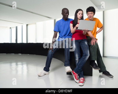 Schwarzer Mann, asiatischen Mann und kaukasischen Frau versammelten sich um einen Laptop-computer Stockfoto