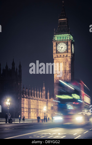 Ein Doppeldecker-Bus vor Big Ben in der Nacht, London, Vereinigtes Königreich Stockfoto