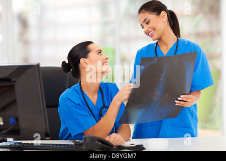 fröhliche Ärztinnen und Ärzte diskutieren über Röntgen im Krankenhaus Stockfoto
