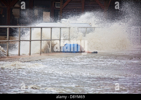 Storm Chaser Jim Edds liegen auf seiner Seite Dreharbeiten entlang der Ufermauer in Downtown Cedar Key Florida während tropischer Sturm Andrea Stockfoto