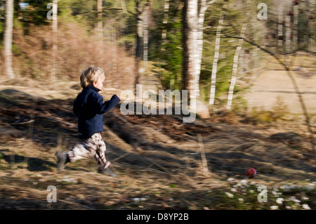 Kleiner Junge im Wald laufen Stockfoto