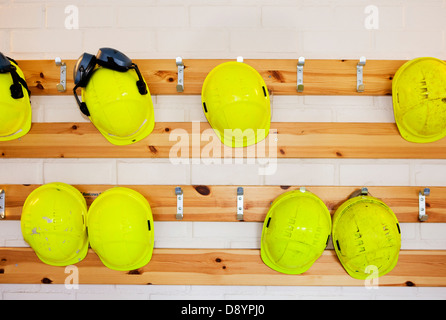 Gelbe harte Hüte hängen rack Stockfoto