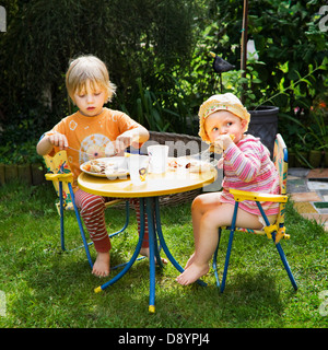 Jungen und Mädchen essen Pfannkuchen im Garten Stockfoto