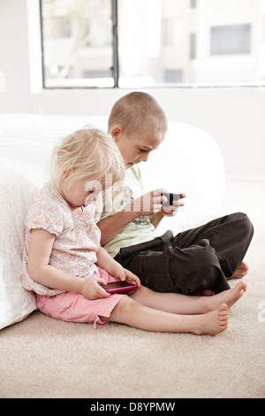 Jungen und Mädchen spielen auf MP3-player Stockfoto