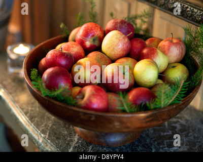 Äpfel in eine Schüssel geben. Stockfoto