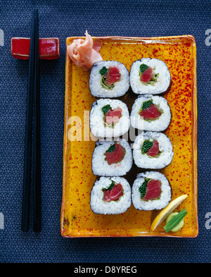 Sushi auf Teller mit Stäbchen Stockfoto